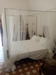 莫托拉masseria chianca " Le Gravine"的客房内的白色床和天蓬