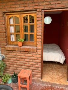 卡皮亚德尔德尔蒙特Malecon en calle Techada Hostel的一个小房子,配有床和窗户