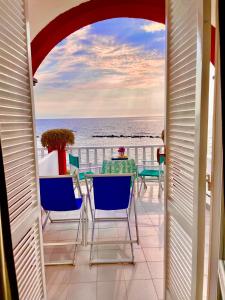 伊斯基亚思科格力拉酒店的一个带桌椅的海景阳台