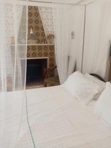 莫托拉masseria chianca " Le Gravine"的带壁炉的客房内的一张白色床