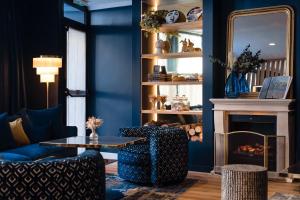 巴黎Hôtel Bleu de Grenelle的客厅设有蓝色的墙壁和壁炉。