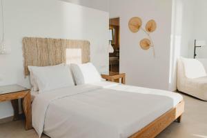 米克诺斯城BAY VIEW RESIDENCE的白色卧室设有一张大床和一张沙发