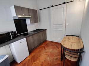 RaismesLa Victorine的厨房铺有木地板,配有木桌。