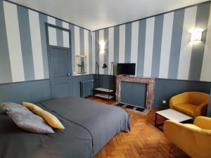 RaismesLa Victorine的一间卧室配有一张床、一台电视和一把椅子