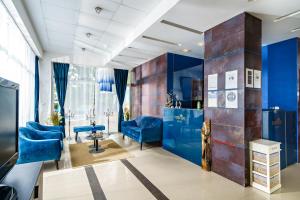 普里莫尔斯科日升酒店的沙龙设有蓝色的墙壁和蓝色的椅子