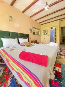 伊姆利尔Riad Atlas Garden的一间卧室配有一张大床,上面有红色毛巾