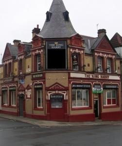 利物浦Brownlows Inn Guest House formerly The King Harry Accommodation的街道边的一座红色大建筑