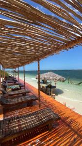 日若卡-迪热里科阿科阿拉Casa B&B的海滩上带椅子和遮阳伞的木制甲板