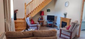 贝尔马利特Ferry View Cottage的带沙发和楼梯的客厅