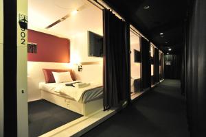 福冈博多第一胶囊旅馆的小房间设有床和窗户