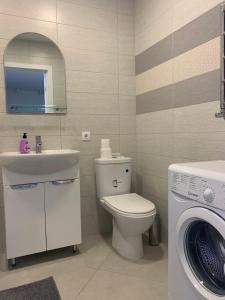 基辅044 Квартира в ЖК "София"的浴室配有卫生间、盥洗盆和洗衣机。