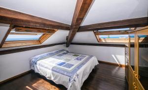 德瓦玛丽娜Tinetto Brezza di mare的一间卧室设有一张床和两个窗户。