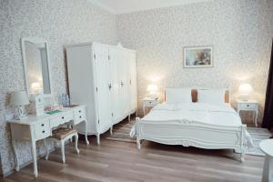 阿巴斯图马尼Abastumani Residence的一间白色卧室,配有一张床和一个梳妆台