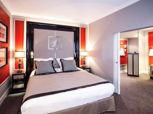 格勒诺布尔Park Hôtel Grenoble - MGallery的一间卧室设有一张带红色墙壁的大床