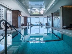 内坦亚David Tower Hotel Netanya by Prima Hotels - 16 Plus的蓝色建筑中的一个大型游泳池