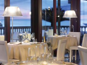 利沃诺GH Palazzo Suite & SPA的用餐室配有带白色椅子的桌子和灯具