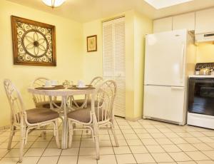 萨拉索塔Siesta Palms By the Beach的厨房配有桌椅和冰箱。
