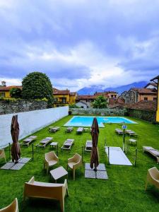赫拉弗多纳劳罗酒店的一个带躺椅的游泳池和一个带桌椅的草坪