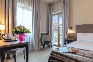 罗马Fragrance Hotel St. Peter的配有一张床、一张书桌和一扇窗户的酒店客房