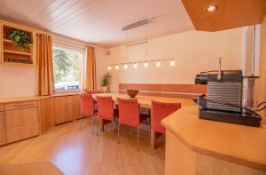 阿罗萨Sans Souci EG的厨房配有长桌子和红色椅子