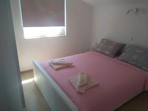 温克兰Edensk vrt classic!!i的粉红色的床,上面有两张餐巾纸