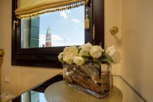 威尼斯黎莱斯威尼斯酒店的花瓶,花瓶上满是白色的花朵,坐在桌子上