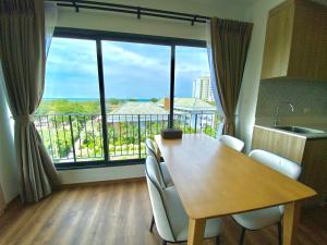华欣La Habana Hua Hin 2 Bedroom Seaview的一间带桌子和大窗户的用餐室