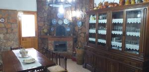艾利翁BOTEROS casa rural的用餐室配有桌子和带葡萄酒瓶的橱柜