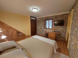 普利莫顿Guest house Paola的一间卧室设有两张床和石墙