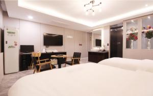 浦项Idea Hotel的配有一张床、一张桌子和一张桌子的酒店客房