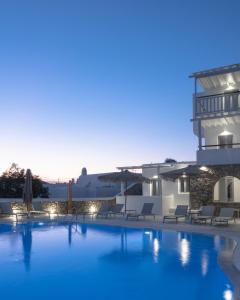 奥诺斯Mykonos Essence Adults Only的享有带椅子的游泳池和大楼的景色