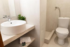 奥林匹亚达德国酒店的白色的浴室设有水槽和卫生间。