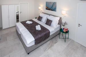 斯普利特Villa Fig的一间卧室配有一张大床和两条毛巾