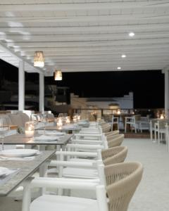 奥诺斯Mykonos Essence Adults Only的用餐室配有白色的桌子和白色的椅子