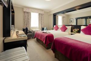 都柏林都柏林阿什林酒店的酒店客房配有两张床和一张书桌