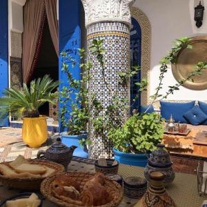 非斯让克洛德摩洛哥传统庭院住宅的餐桌上放有植物的盘子的桌子