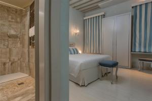 威尼斯黎莱斯威尼斯酒店的一间卧室配有一张床,浴室设有浴缸