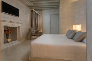 威尼斯黎莱斯威尼斯酒店的一间白色卧室,配有一张床和一个壁炉