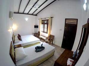 安伯朗戈德Ramon beach resort的客房设有两张床、一把椅子和窗户。