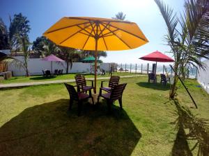 安伯朗戈德Ramon beach resort的一张桌子和椅子,放在大黄伞下