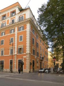 罗马罗坎达凯洛利酒店的一座大型橙色建筑,前面设有停车场