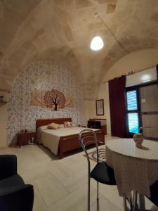 利扎诺Il Sole di Puglia B&B的一间卧室配有一张床和一张桌子及椅子