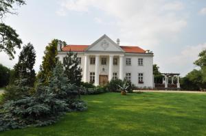 RogowoRestauracja - Hotel Pałacowa的一座带绿色庭院的大型白色房屋