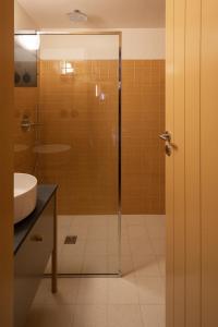 波尔图Na Travessa Suítes的一间带玻璃淋浴和水槽的浴室