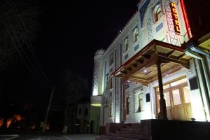 撒马尔罕苏丹精品酒店的一座建筑,在晚上前方有标志