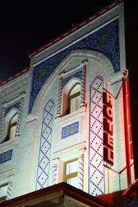撒马尔罕苏丹精品酒店的前面有 ⁇ 虹灯标志的建筑
