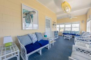 比奇港迎温沃德海滩宾馆的客厅配有蓝色的沙发和椅子