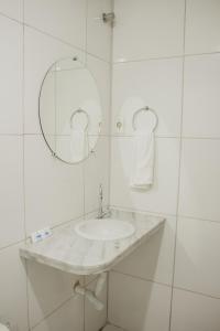 特里温福Pousada Alpes的白色的浴室设有水槽和镜子