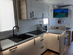 普拉Floating House SENA的厨房配有白色橱柜和水槽