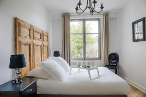欧赖Résidence L'Aristide Appartement Louison的卧室设有一张白色大床和一扇窗户。